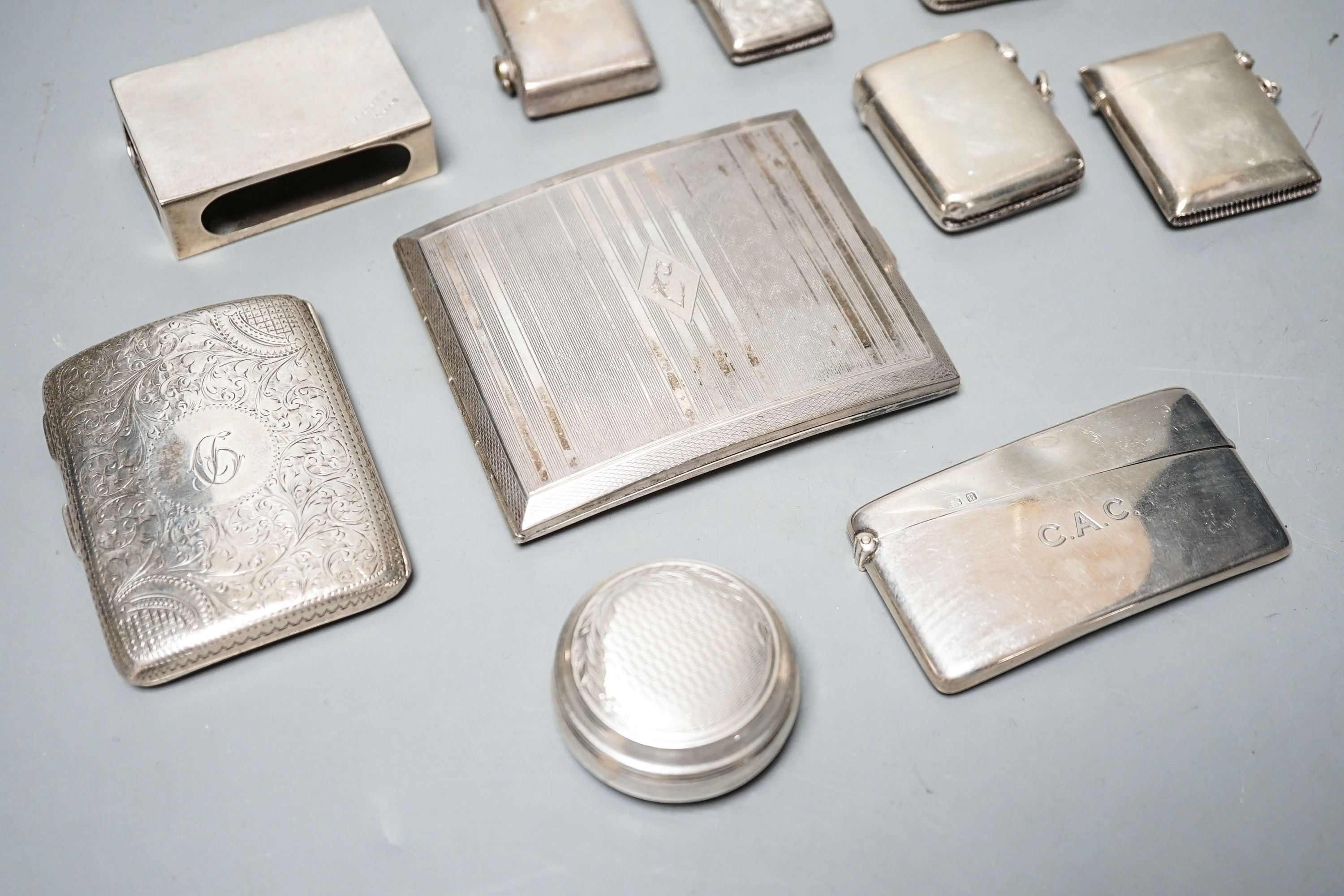 A group of assorted small silver to include four vesta cases, two cigarette cases (one plated), a card case, pill box, match sleeve and white metal mounted lighter.